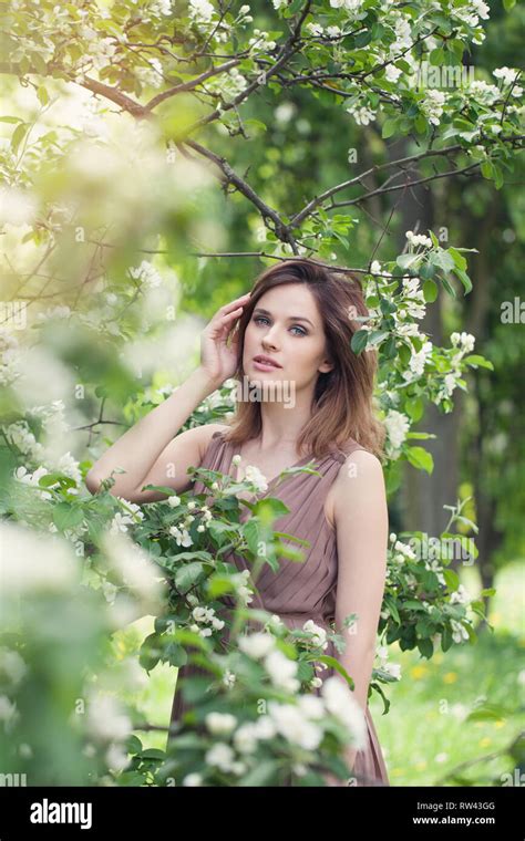 Pretty woman in spring. Beautiful girl on floral nature background ...