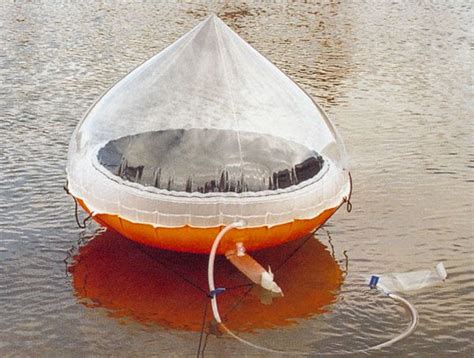 an orange and white boat floating on top of water