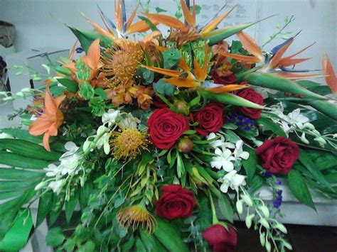 Masculine casket spray with a tropical look and feel. It features birds of paradise, pin cushion ...