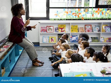 Students Sitting on the Floor Listening To Teacher Stock Photo - Image ...