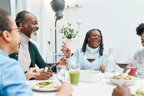 "Family Laughing Over Dinner At Home" by Stocksy Contributor "Ivan ...