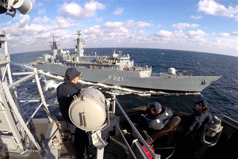 Crew aboard the USS Carney (DDG-64) observe replenishment-at-sea training with the Romanian Navy ...