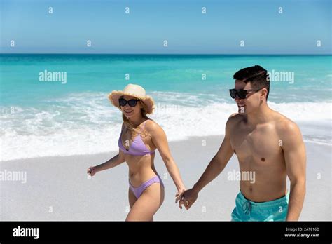 Young couple holding hands at the beach Stock Photo - Alamy