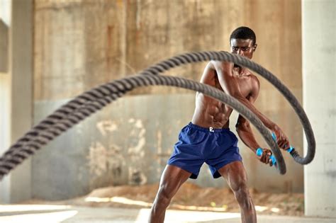 Premium Photo | Rope workout sport man doing battle ropes exercise ...