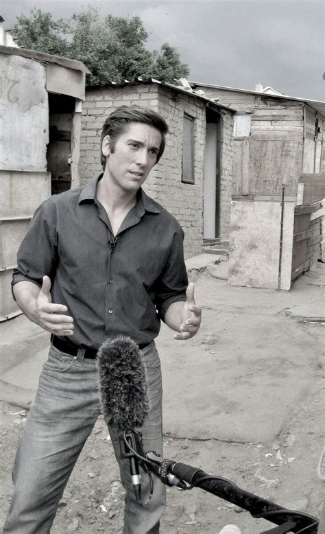 a man standing next to a microphone in front of a building with no roof ...