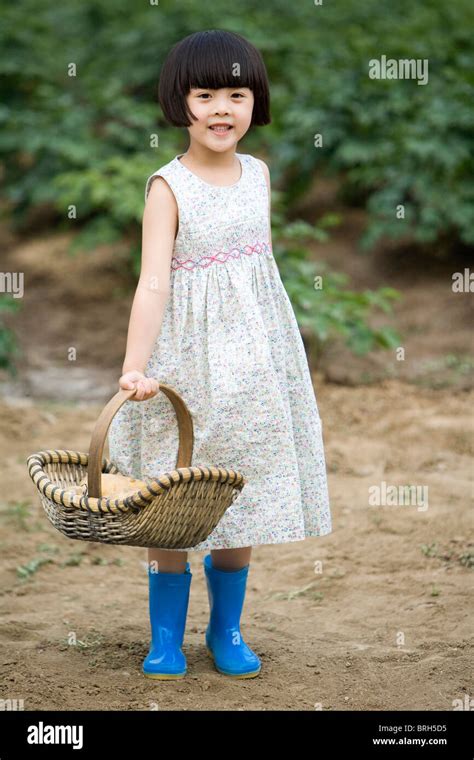 Little girl holding basket in farm Stock Photo - Alamy