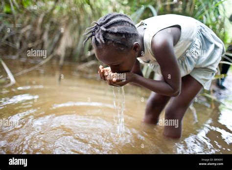 African child drinking dirty water hi-res stock photography and images - Alamy