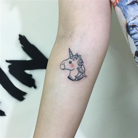 a small unicorn tattoo on the arm