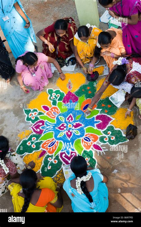 Indian teenage girls making a rangoli sankranthi festival design on a rural road. Andhra Pradesh ...