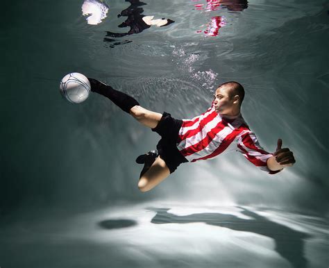 Young Man Underwater Playing Football Photograph by Henrik Sorensen