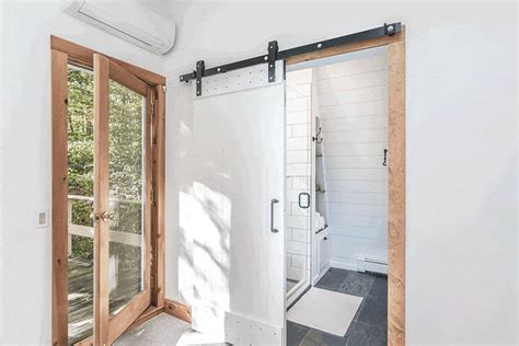 We love the simple contrast of the white, sliding barn door against the wood frame leading into ...