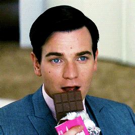 a man in a suit eating a chocolate bar