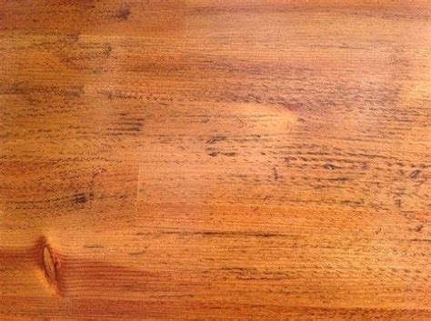a close up view of a wooden surface with some stains on it and the wood grains are brown