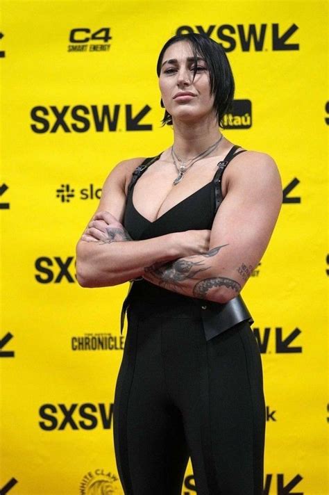 a woman with her arms crossed standing in front of a yellow background ...