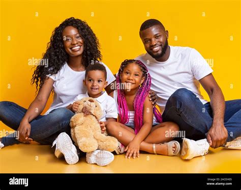 Portrait of happy millennial black parents with two little kids Stock ...