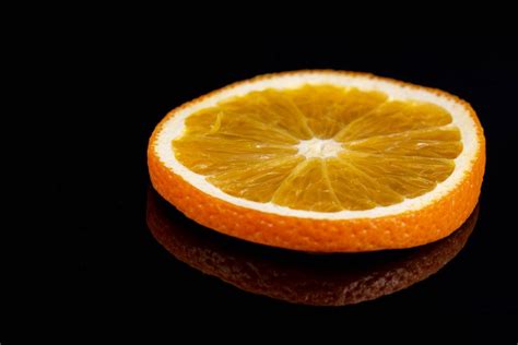 Fruit background with half a grapefruit, orange, lemon and mandarin on a black background, top ...
