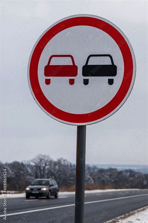 Snowy road with traffic sign Overtaking prohibited. Road in the ...