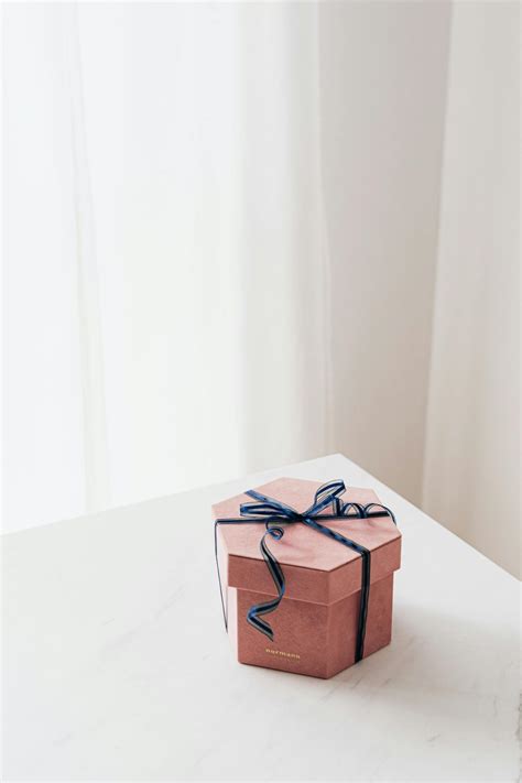 Wrapped with ribbon gift box placed on table · Free Stock Photo