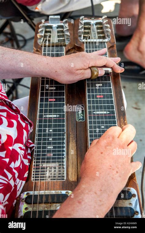 A musician plays a double-neck lap steel Hawaiian guitar at a community ...