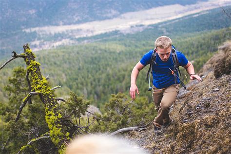 "Young Man Climbing Up Steep Hill On A Mountain Overlooking A Forest Valley" by Stocksy ...