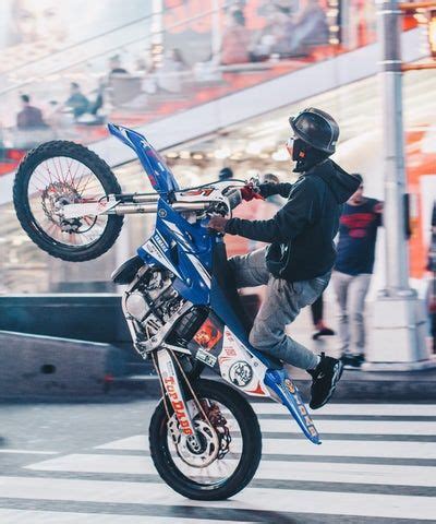 selective focus photography of man doing wheelie on motocross dirt bike ...