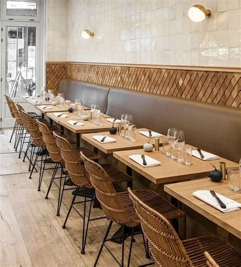 an empty restaurant with wooden tables and wicker chairs in front of ...