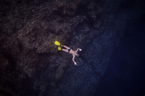 Premium Photo | Unrecognizable man in flippers swimming under dark water