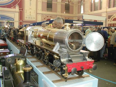 an old fashioned train on display in a museum with people looking at it ...