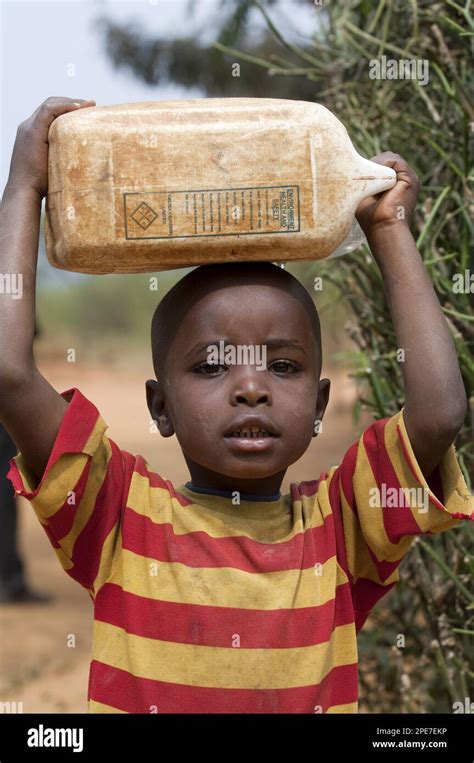 Rwanda woman collecting water hi-res stock photography and images - Alamy