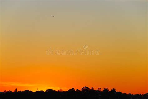 Airplane Flying at Dusk Against an Orange Colored Sky Stock Photo - Image of flying, sunlight ...