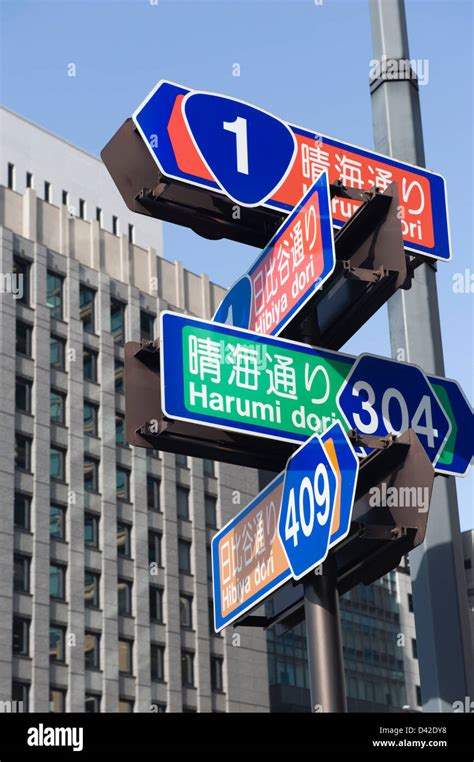 Downtown Tokyo street signs at intersection of Harumi-dori and Hibiya-dori streets, bend in ...