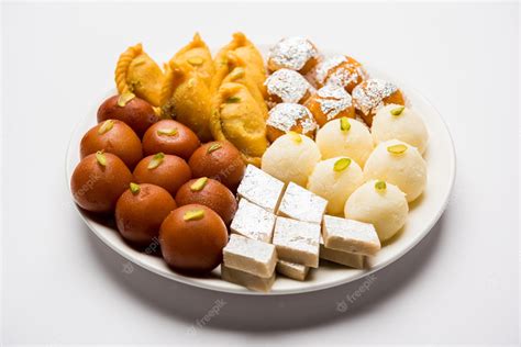 Premium Photo | Indian sweets in a plate includes Gulab Jamun, Rasgulla, kaju katli, morichoor ...