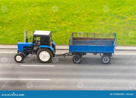 Blue Tractor with a Trailer Driving on the Highway Stock Image - Image ...