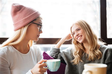 Two cheerful charming young women drinking coffee and talking in cafe Royalty-Free Stock Image ...