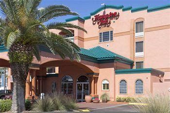 the exterior of a hotel with palm trees