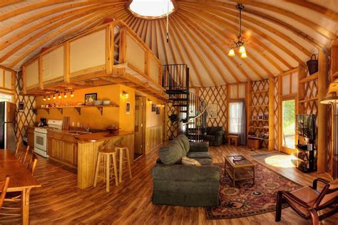 a living room filled with furniture next to a kitchen and dining area in a wooden structure