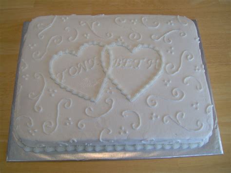 a white cake with two hearts on it