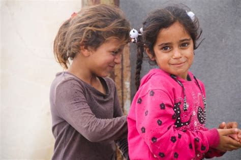 Premium Photo | Cute syrian children in a refugee camp in the rain