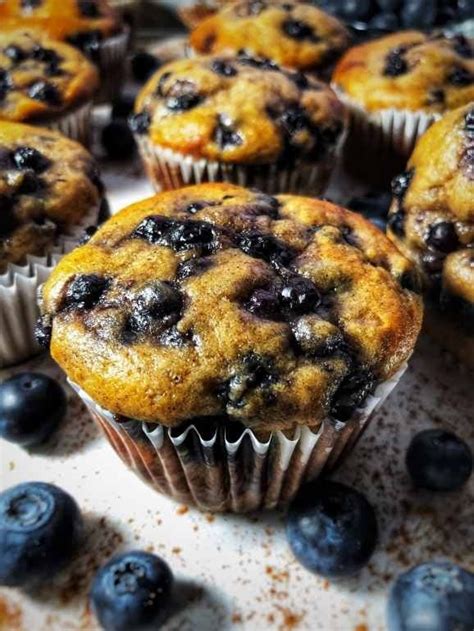 blueberry muffins with fresh blueberries scattered around them