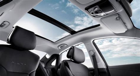 the inside of a car with its sunroof and roof lights on, looking up at ...