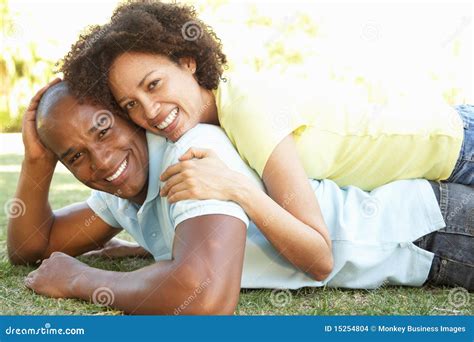 Portrait of Young Couple Laying on Grass in Park Stock Photo - Image of portrait, laying: 15254804