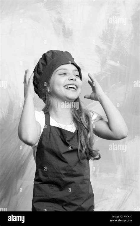 child or happy little girl cook in red chef hat and apron on colorful abstract background ...