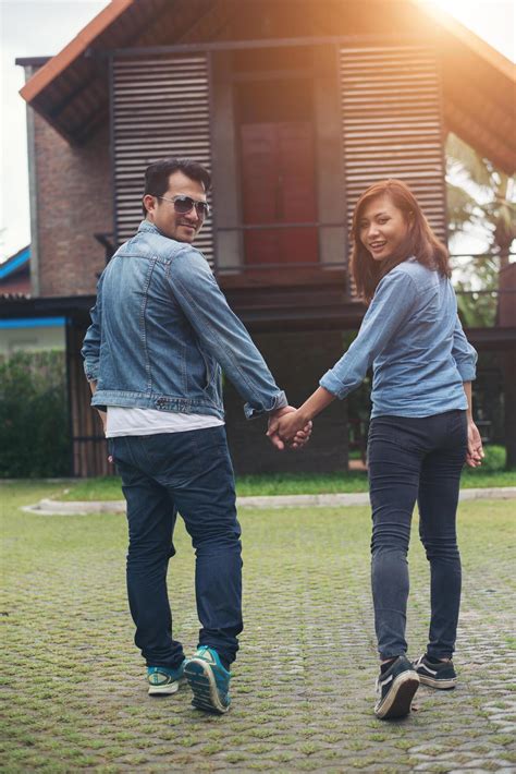 Close-up of loving couple holding hands while walking outdoor, Looked back and smile to camera ...