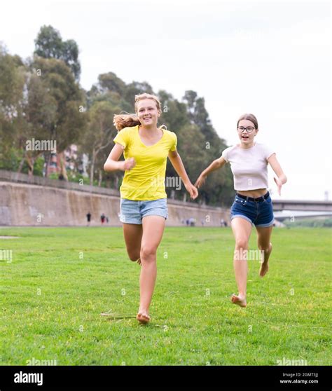 Young barefoot girls running through grass Stock Photo - Alamy