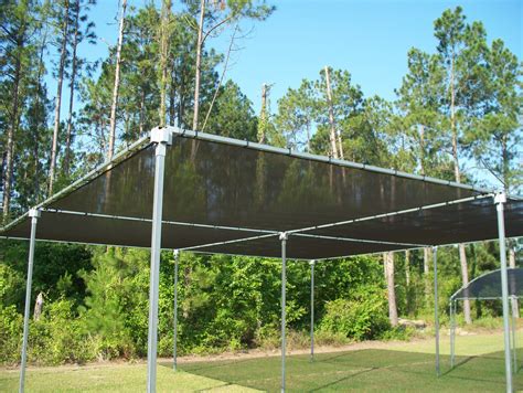 an outdoor shelter in the middle of a grassy area with trees and bushes behind it