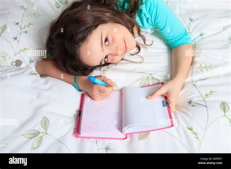 Girl writing diary in bed Stock Photo - Alamy