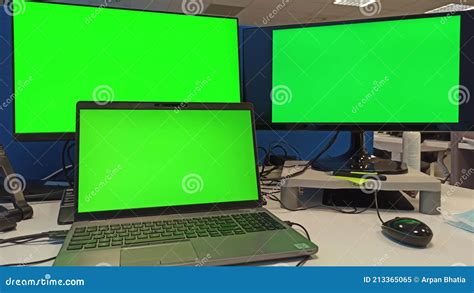 Workstation of 3 Computer Monitor on Desk with Green Screen in 4k. One Laptop Connected with 2 ...