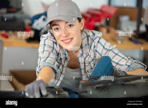 female mechanic uses power tool in the workshop Stock Photo - Alamy