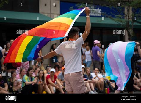 People wave the rainbow pride flag and a trans flag at the 2022 Toronto Pride Parade Stock Photo ...