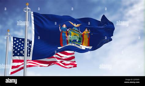 The New York state flag waving along with the national flag of the ...